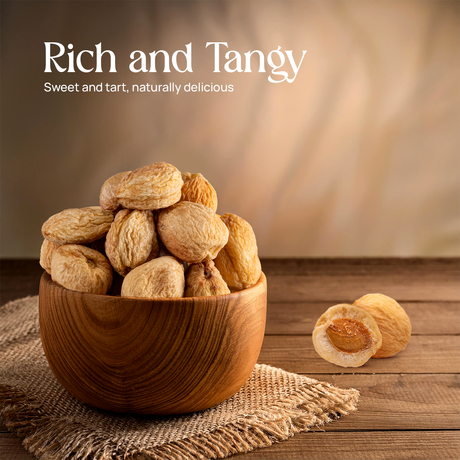 Dried apricots in a wooden bowl, golden fruit with one halved piece