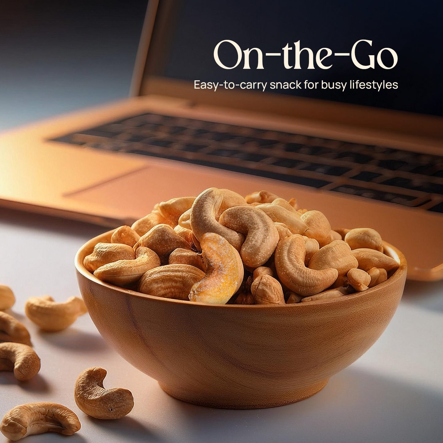 Bowl of cashews with a laptop in the background, snack-on-the-go theme