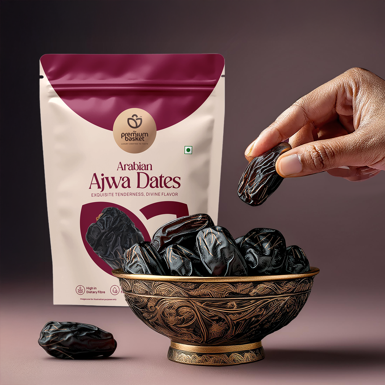 Hand holding Ajwa date fruit with dates pouch and ornate bowl